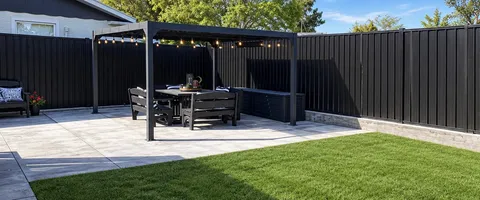 Black Colorbond fence around a patio with pergola and lawn, Palmerston North