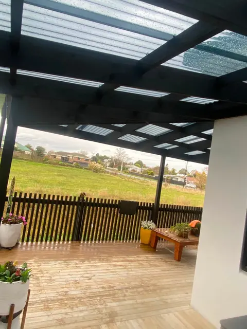Covered timber deck outside sliding doors with a dark screen fence, Palmerston North