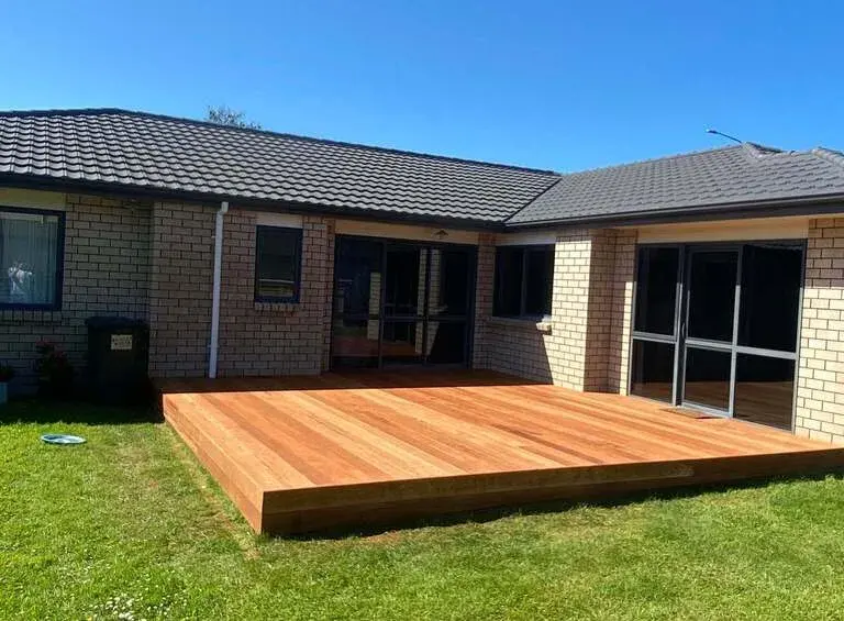 Ground-level timber deck on a lawn beside a brick home, Palmerston North